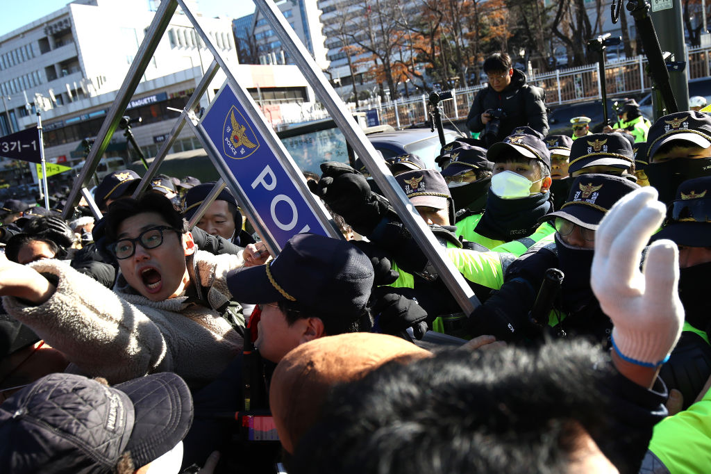 SEOUL, SÜDKOREA - 30. NOVEMBER: Hundezüchter ringen mit Polizeibeamten während eines Protests, bei dem sie die Regierung auffordern, die Pläne zur Verabschiedung eines Gesetzes zum Verbot des Verzehrs von Hundefleisch zu verwerfen, vor dem Büro des Präsidenten am 30. November 2023 in Seoul, Südkorea. Die Landwirte argumentierten, dass ein Verbot des umstrittenen Hundefleischs auf den Speisekarten des Landes sie ihrer Lebensgrundlage berauben würde. Als die südkoreanische Regierung vor etwa einer Woche ihren Plan bekannt gab, ein Verbot von Hundefleisch einzuführen, feierten Tierschutzorganisationen. (Foto von Chung Sung-Jun/Getty Images)