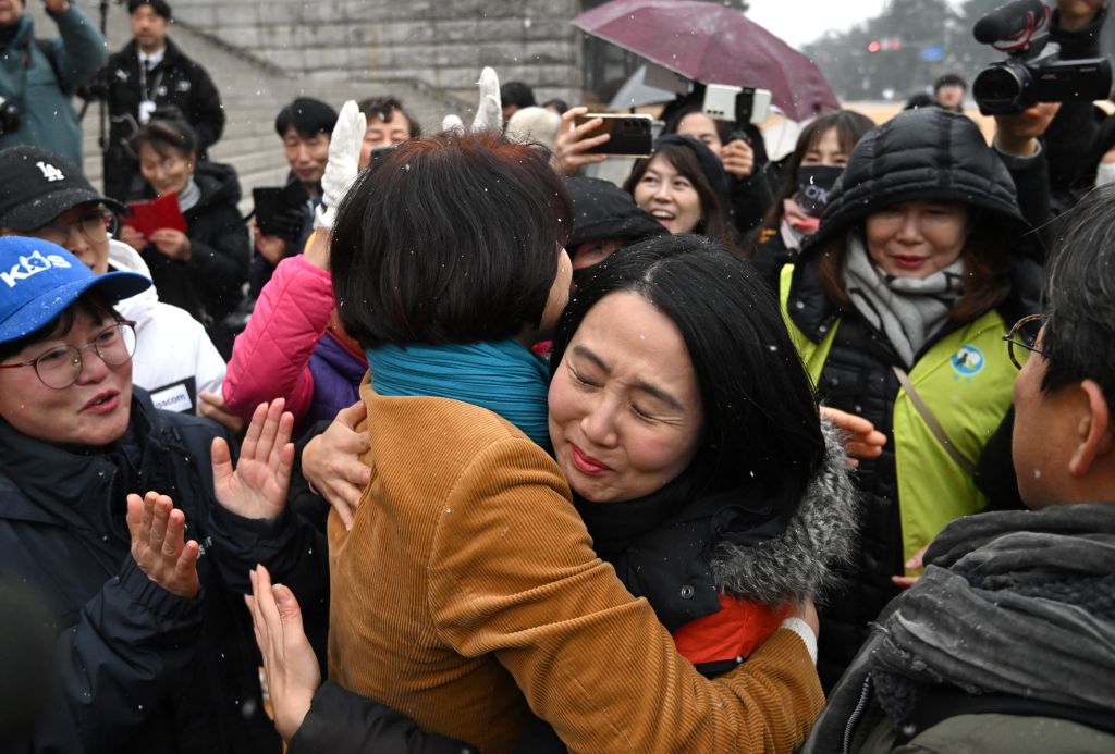 Южнокорейският депутат Хан Чонг-ае (в средата Л) празнува с активисти за правата на животните по време на митинг, на който се приветства законопроектът за забрана на търговията с кучешко месо в Националното събрание в Сеул на 9 януари 2024 г. На 9 януари парламентът на Южна Корея прие законопроект за забрана на отглеждането, клането и продажбата на кучета за месо - традиционна практика, която активистите отдавна наричат срам за страната. Официалната подкрепа за забраната нарасна под ръководството на президента Юн, самопровъзгласил се любител на животните, който е осиновил няколко бездомни кучета и котки заедно с първата дама Ким - която сама е яростен критик на консумацията на кучешко месо. (Снимка: Jung Yeon-je / AFP) (Снимка: JUNG YEON-JE/AFP via Getty Images)