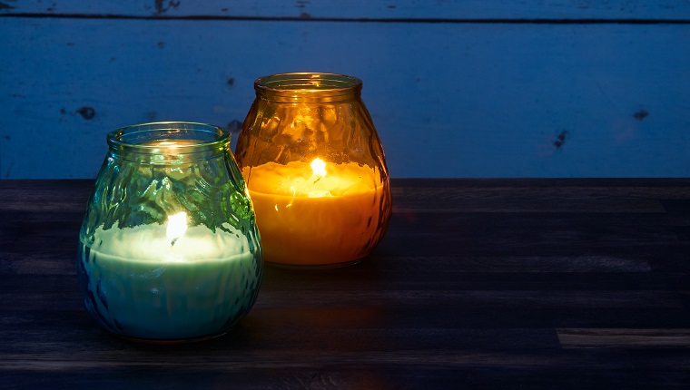 Сини и жълти свещи цитронела, запалени в градината, се използват за предпазване от комари в късната вечер
