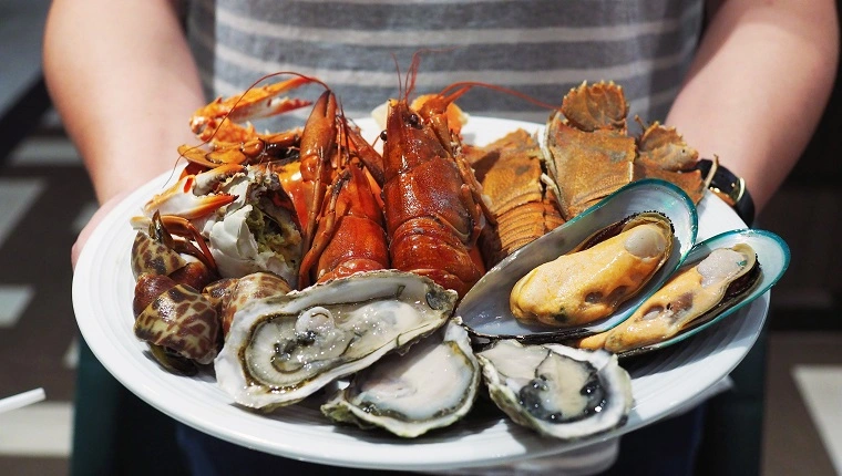 Teller mit gedämpften Flusskrebsen, Riesenflussgarnelen, Muscheln, Riesenkrabben und frischen Austern. Meeresfrüchte am Buffet.