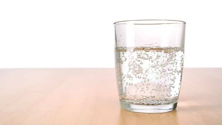 Glas mit kohlensäurehaltigem Wasser auf dem Tisch